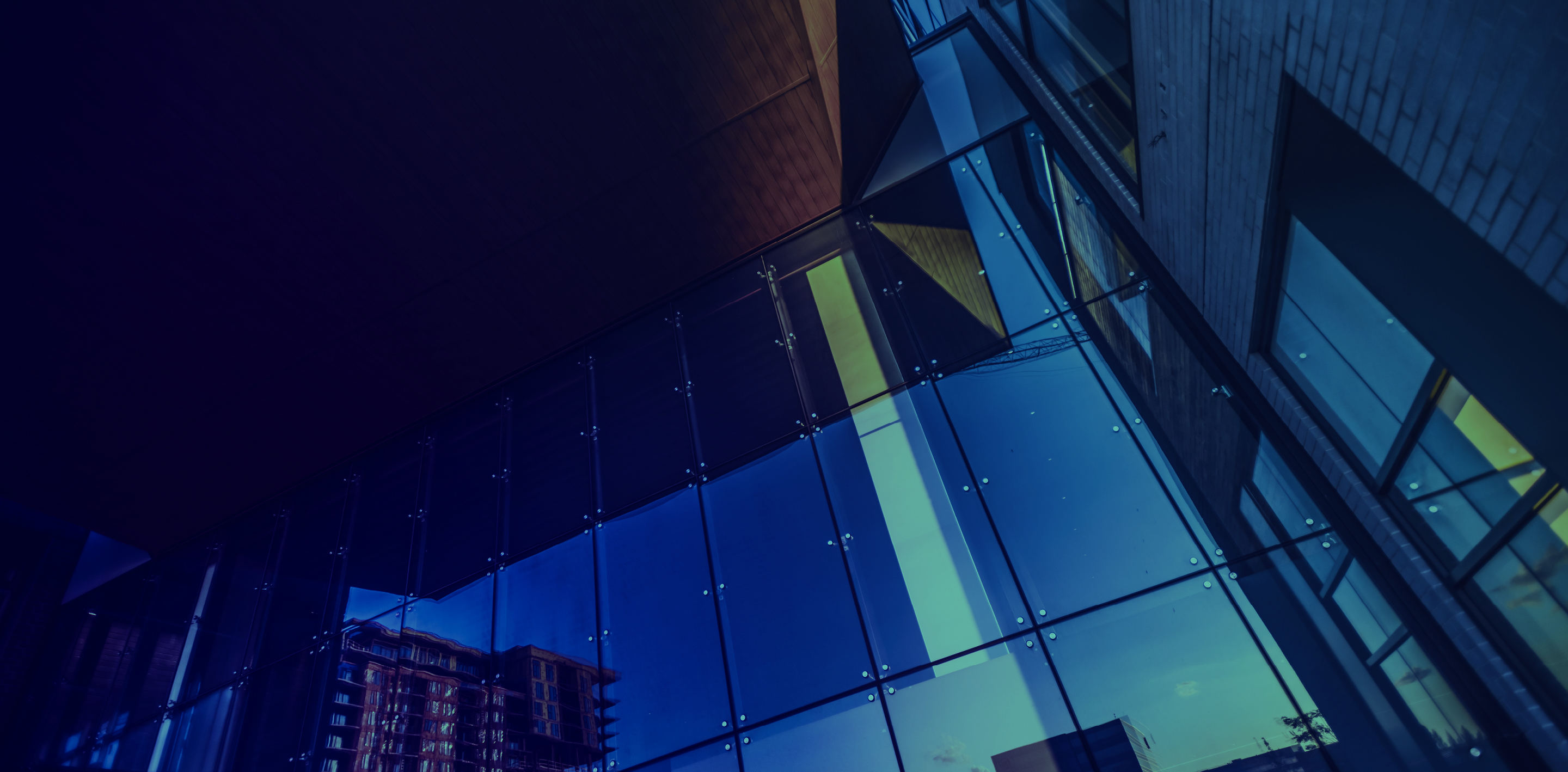 A modern architectural scene featuring tall glass buildings reflecting the city skyline, captured from a low angle with blue and purple tones, symbolizing innovation, transparency, and corporate professionalism.